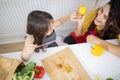 Little girl and her mother slicing vegetables on a cutting board Royalty Free Stock Photo