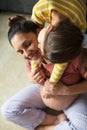 Happy little girl with her pregnant mom at home. Little girl kissing and hugging pregnant her mom Royalty Free Stock Photo