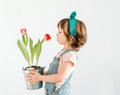 Happy Little girl is holdinf red tulips against a white background. Spring and Easter concept Royalty Free Stock Photo