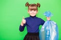 Happy little girl holding garbage bag with plastic trash and showing winning gesture isolated on green