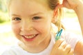 Happy little girl holding hair clip