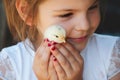 Happy little girl holds a chicken in his hands. Child with poul