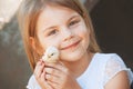 Happy little girl holds a chicken in his hands. Child with poul