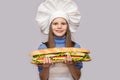 Happy little girl with hot dog and chef uniform isolated on white background Royalty Free Stock Photo