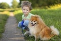 Happy little girl hugging dog in autumn park, summer field. child playing with puppy outdoors. Royalty Free Stock Photo