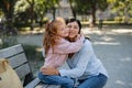 Happy little girl hugging her grandmother outdoors in park. Royalty Free Stock Photo