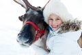 Happy little girl hugging her reindeer. Winter playtime. Royalty Free Stock Photo