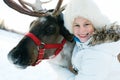 Happy little girl hugging her reindeer. Winter playtime. Royalty Free Stock Photo