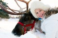 Happy little girl hugging her reindeer. Winter playtime. Royalty Free Stock Photo