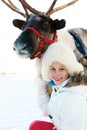 Happy little girl hugging her reindeer. Winter playtime. Royalty Free Stock Photo