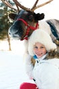 Happy little girl hugging her reindeer. Winter playtime. Royalty Free Stock Photo