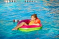 Happy little girl with inflatable toy ring float in swimming pool. Little preschool child learning to swim and dive in Royalty Free Stock Photo