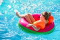 Happy little girl with inflatable toy ring float in swimming pool. Little preschool child learning to swim and dive in Royalty Free Stock Photo