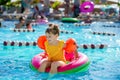 Happy little girl with inflatable toy ring float in swimming pool. Little preschool child learning to swim and dive in Royalty Free Stock Photo