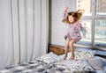 Happy little girl jumping on bed. Happy and carefree childhood Royalty Free Stock Photo