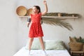 Happy little girl jumping on bed, singing a song Royalty Free Stock Photo