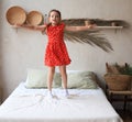 Happy little girl jumping on bed, singing a song Royalty Free Stock Photo