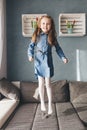 Happy little girl jumping on couch at home Royalty Free Stock Photo