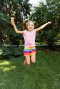 Happy little girl jumping in the park. little girl eating ice cream and having fun in the city Royalty Free Stock Photo