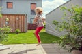 Happy little girl jupping with skipping rope on backyard at sunny day while summer holidays Royalty Free Stock Photo