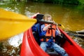 Happy little girl on a kayak on a river