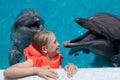 Happy Little Girl Laughing with two Dolphins in Swimming Pool Royalty Free Stock Photo