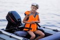 Happy little girl with life vests, having fun on a boat trip while on holiday in lake