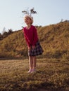 Happy little girl with long hair portrait jumping on nature background windy day. Cute kid walking alone in autumn park