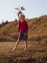 Happy little girl with long hair portrait jumping on nature background windy day. Cute kid walking alone in autumn park