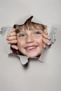 Happy little girl looking out of a hole Royalty Free Stock Photo