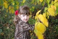 Happy little girl looks away next to yellow trees Royalty Free Stock Photo