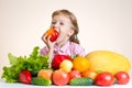 Happy little girl and a lot of fruit and vegetables.