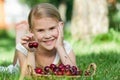 Happy little girl lying near the tree with a basket of cherries Royalty Free Stock Photo