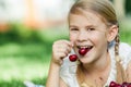 Happy little girl lying near the tree with a basket of cherries Royalty Free Stock Photo