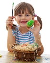 A happy little girl painting easter eggs