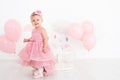 happy little girl in pink dress celebrating her first birthday with balloons Royalty Free Stock Photo