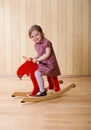 Happy little girl play with toy wooden deer Royalty Free Stock Photo