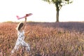 Happy little girl playing with airplane on a lavender field during sunset. Children play toy airplane. Little girl wants Royalty Free Stock Photo
