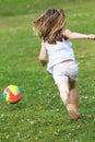 Happy little girl playing ball in the park. Royalty Free Stock Photo