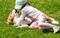 Happy little girl playing with beagle dog in garden. Royalty Free Stock Photo