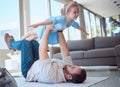 Happy little girl playing with her father in the lounge. Caucasian father lifting his daughter in the air, lying on the Royalty Free Stock Photo