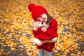 Happy little girl playing with his teddy bear toy in autumnal park Royalty Free Stock Photo