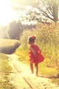 Happy little girl playing on meadow, sunset, summertime