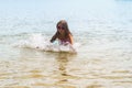 Happy little girl playing in shallow water waves Royalty Free Stock Photo