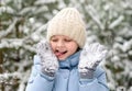 Happy little girl playing with snow on her mittens. A child in warm winter clothes. Walking and active rest in winter Royalty Free Stock Photo