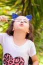 Happy little girl playing with soap bubbles on a summer nature, wearing a blue ears tiger accessories over her head in a Royalty Free Stock Photo