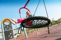 Happy little girl playing on a swing and having fun at kids modern playground Royalty Free Stock Photo