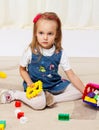 Happy little girl playing with toys