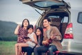 Happy little girl playing ukulele with asian family sitting in the car for enjoying road trip and summer vacation Royalty Free Stock Photo