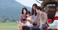 Happy little girl playing ukulele with asian family sitting in t Royalty Free Stock Photo